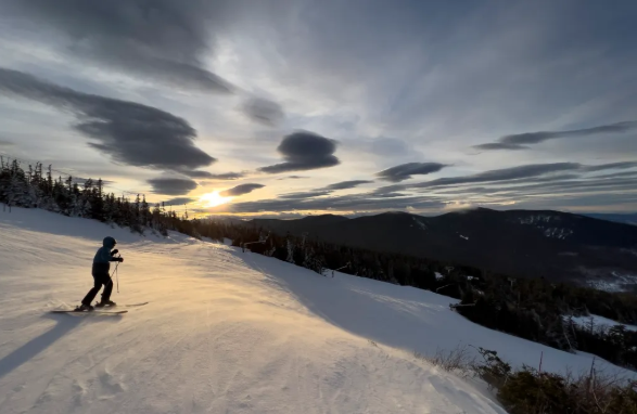 As the sun begins to set, a skier starts their last run of the day at Sugarloaf in Carrabassett Valley on January 18. Gregory Rec/Staff Photographer